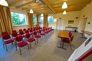 Sala de conferencias con sillas rojas y mesa en Golf Club Cavaglià, en Cavaglià