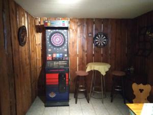 a dart machine in a room with a table and stools at Pension und Gasthof Zur Scheune in Flecken Zechlin +11 photos