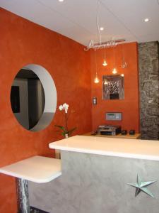 una cucina con pareti arancioni e specchio di Le Mas d'Estello a Tallard