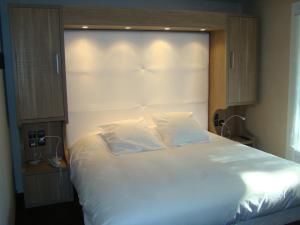 ein Schlafzimmer mit einem großen weißen Bett mit einem großen Kopfteil in der Unterkunft Le Mas d'Estello in Tallard
