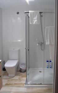 a white bathroom with a shower and a toilet at NWT Central Station Apartments in Valencia