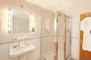 łazienka z prysznicem, umywalką i lustrem w obiekcie Jock Scott Cottage w mieście Dunkeld +4 zdjęcia