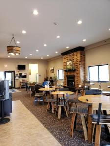 a restaurant with tables and chairs and a fireplace at Cobblestone Inn & Suites - Manning in Manning