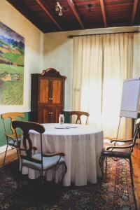 a room with a table with chairs and a painting at Pontac Manor Hotel & Restaurant in Paarl