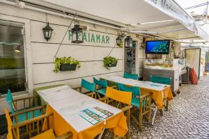 una fila di tavoli e sedie fuori da un ristorante di Sesimbra Prime Apartment by be@home a Sesimbra