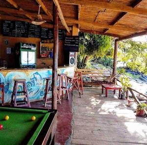 a pool table in front of a bar with a pool table at Butterfly Space- A Non-Profit Eco-Lodge in Nkhata Bay