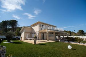 une maison avec une grande cour avec une pelouse dans l'établissement Rainone Resort - San Marco di Castellabate, à Castellabate