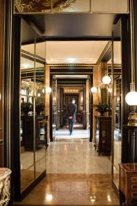 une personne marchant dans un couloir avec un parasol dans l'établissement La Réserve Paris Hotel & Spa, à Paris