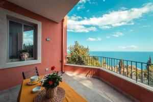 einen Balkon mit einem Tisch und Meerblick in der Unterkunft The charming house in Taormina