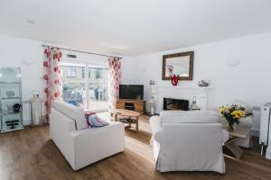 a living room with two white couches and a fireplace at Elysian Fields B&B in Helston