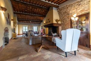 ein Wohnzimmer mit einer Ziegelwand, einem Tisch und Stühlen in der Unterkunft Pieve Marsina & Borgo Argenina in Monti di Sotto