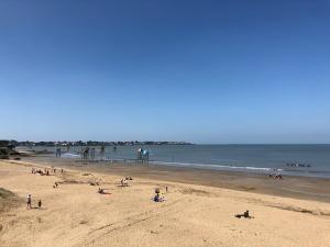 un grupo de personas en una playa cerca del océano en la Patelle, en La Plaine-sur-Mer