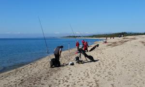 un grupo de personas pescando en una playa con un perro en L'isola di Gaia, en Crotone