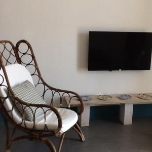 uma sala de estar com uma cadeira e uma mesa com uma televisão em Casa Nonnona em Palermo