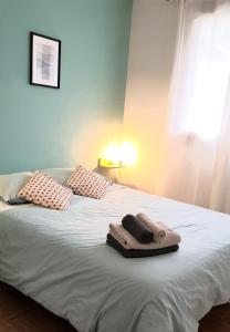 a bed with two pillows and towels on it at Chambre privée entre Paris et Disneyland in Noisy-le-Grand