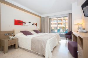 a hotel room with a bed and a balcony at Hipotels Playa La Barrosa - Adults Only in Chiclana de la Frontera