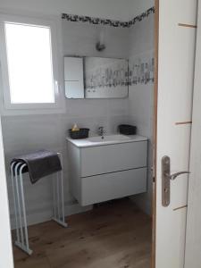 uma casa de banho branca com um lavatório e uma janela em Lili em Céret