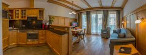 kuchnia z drewnianymi szafkami i salon w obiekcie Abanico Appartements w mieście Seefeld in Tirol