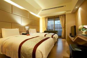 um quarto de hotel com duas camas e uma televisão em Master Hotel em Taipei