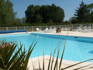 a large swimming pool with chairs and a fence at Camping La Verte Prairie in Forest-Montiers