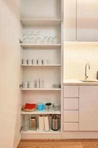 a kitchen pantry with white cabinets and a sink at Ouro Grand by Level Residences in Lisbon