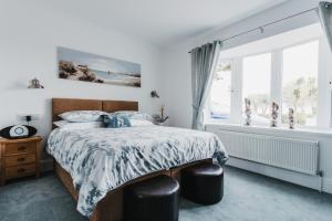 een slaapkamer met een bed en een raam bij Elysian Fields B&B in Helston