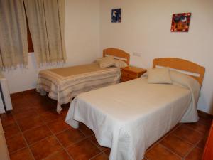 a room with two beds and a tiled floor at Apartamento Alcala de la selva in Alcalá de la Selva