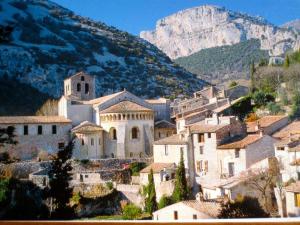 a group of buildings in a town with a mountain at CHARMANTE MAISON A SAINT GUILHEM LE DESERT in Saint-Guilhem-le-Désert