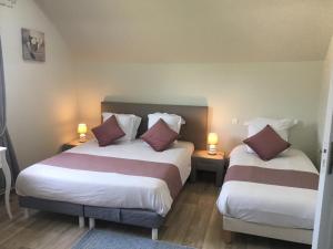 two beds in a hotel room with two lamps at B&B de Saint Come de Fresné in Saint-Côme-de-Fresné