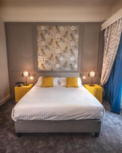 a bedroom with a large bed with two yellow night stands at Grand Hotel Bellevue - Grand Place in Lille