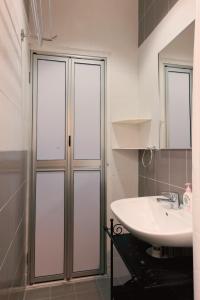 bagno con lavandino e doccia in vetro di The One Vacation Home a Malacca