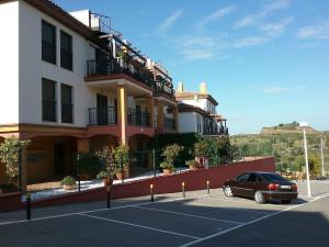 une voiture garée sur un parking devant un immeuble dans l'établissement Costa Esuri Golf y Playa, à Ayamonte