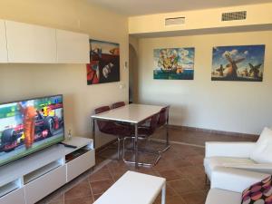 un salon avec une télévision et une table dans l'établissement Costa Esuri Golf y Playa, à Ayamonte