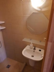 een kleine badkamer met een wastafel en een licht bij Tajek in Stegna