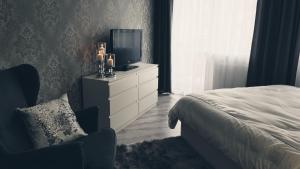 een slaapkamer met een bed en een televisie op een dressoir bij Silver Apartaments in Piła