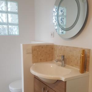 W łazience znajduje się umywalka i lustro. w obiekcie Le Clos de Carinette w mieście Châteauneuf-du-Pape