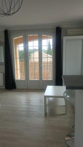 salon z białym stołem i oknami w obiekcie Le Clos de Carinette w mieście Châteauneuf-du-Pape