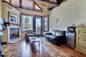 a living room with a leather couch and a fireplace at Les Condos Du Lac Taureau- Rooms & Condos in Saint-Michel-des-Saints
