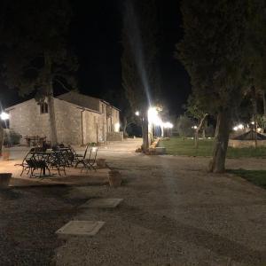 un grupo de mesas y bancos en un parque por la noche en La Tenuta di Castelvecchio, en San Gimignano