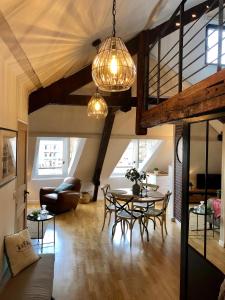 een woonkamer met een tafel en stoelen bij Lucarne Enchantée in Honfleur