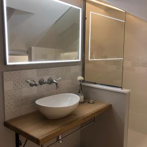 een badkamer met een witte wastafel en een spiegel bij Lucarne Enchantée in Honfleur +9 foto's