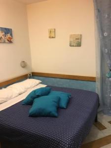 a bed with blue pillows on it in a room at Affittacamere La Baia Di Lerici in Lerici