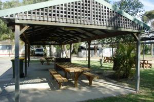 un refugio de picnic con bancos en un parque en Acclaim Swan Valley Tourist Park, en West Swan