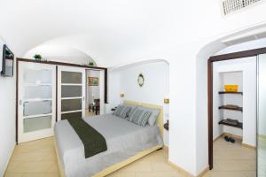 a bedroom with a bed in a white room at Maison Rosa in Positano