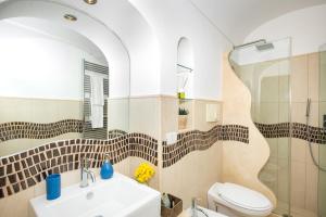 a bathroom with a sink and a toilet and a mirror at Maison Rosa in Positano +51 photos