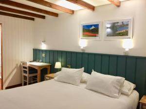 um quarto com uma cama branca e uma parede verde em Hotel Frutillar em Frutillar