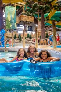 three girls are riding on an inflatable at Timber Ridge Lodge and Waterpark in Lake Geneva