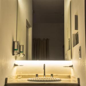 ein Bad mit einem Waschbecken und einem Spiegel in der Unterkunft Ch Loreto Hotel Boutique in Ciudad de Loreto