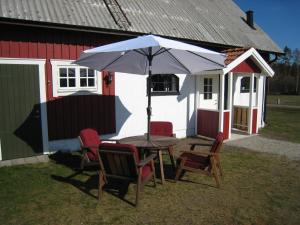 a table with chairs and an umbrella in front of a house at stixered fegen in Fegen