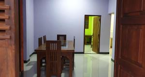 a dining room with a wooden table and chairs at Ambel Homestay in Anuradhapura